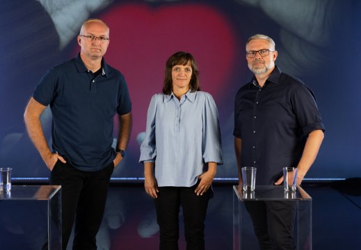 Tre personer som står sammen i studiosetting-